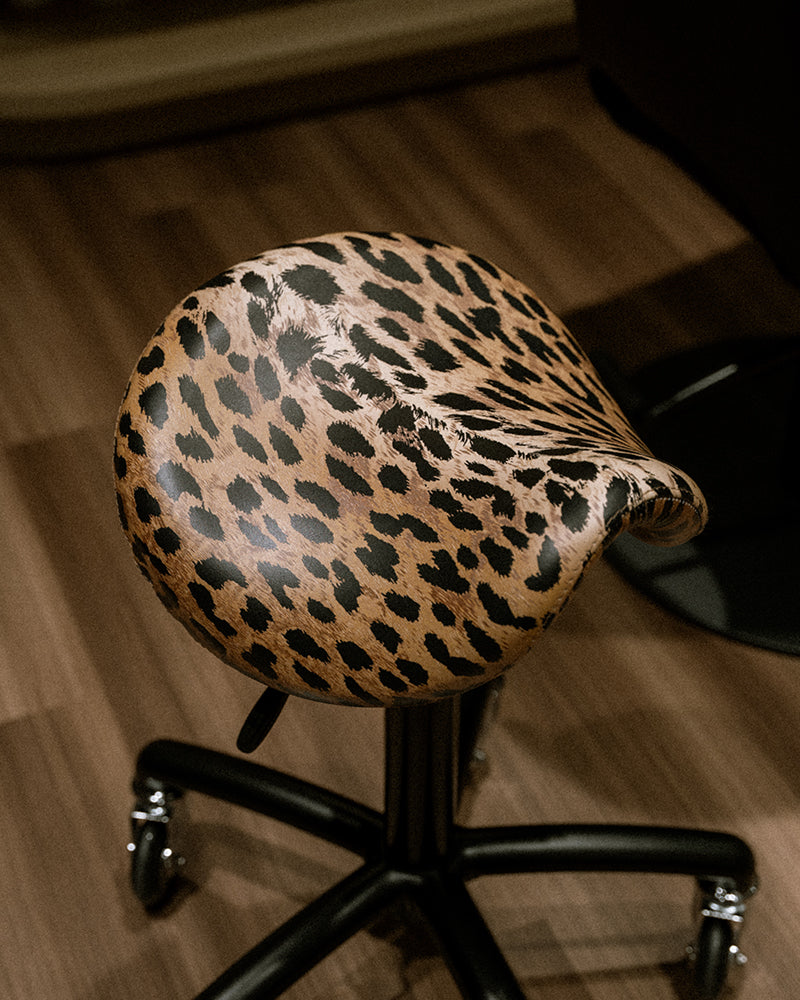 Stella - schwarzer Sattelhocker mit Leopardenbezug und Rollenrädern
